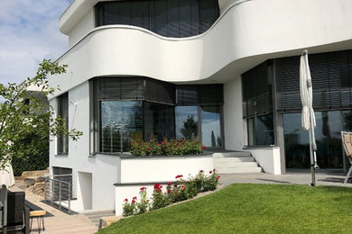 Großes, Zweistöckiges Modernes Einfamilienhaus mit Putzfassade, weißer Fassadenfarbe, Flachdach und Misch-Dachdeckung in Frankfurt am Main