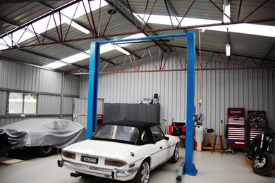 Idée de décoration pour un grand garage pour trois voitures séparé urbain avec un bureau, studio ou atelier.