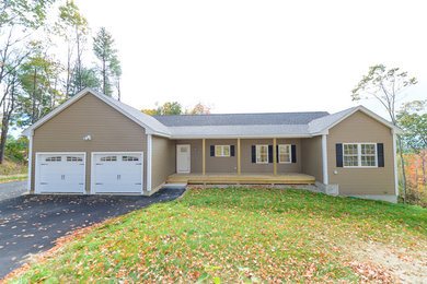 Inspiration for a huge contemporary beige one-story vinyl exterior home remodel in Manchester with a shed roof