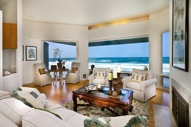 Mid-sized elegant formal medium tone wood floor and brown floor living room photo in San Diego with white walls, a standard fireplace, a tile fireplace and no tv