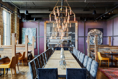 Idées déco pour une grande salle à manger ouverte sur le salon montagne avec un mur violet, un sol en bois brun et un sol marron.