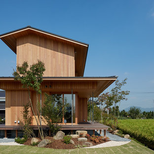 他の地域のアジアンスタイルのおしゃれな家の外観 (木材サイディング、茶色い外壁、切妻屋根) の写真