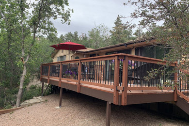 Mid-sized trendy backyard mixed material railing deck photo in Other