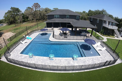 Huge minimalist backyard brick and l-shaped pool house photo in Orlando
