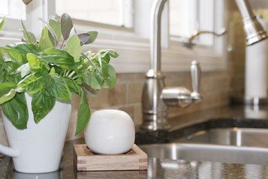 Large transitional u-shaped porcelain tile kitchen photo in Toronto with a double-bowl sink, raised-panel cabinets, white cabinets, granite countertops, beige backsplash, stone tile backsplash, stainless steel appliances and a peninsula