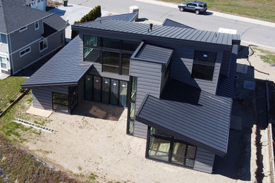 Mid-sized modern gray two-story mixed siding and clapboard house exterior idea in Seattle with a shed roof, a metal roof and a black roof