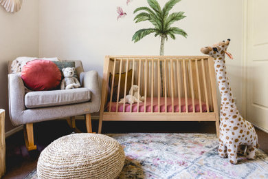 Design ideas for a mid-sized tropical nursery for girls in Wollongong with white walls, carpet and grey floor.