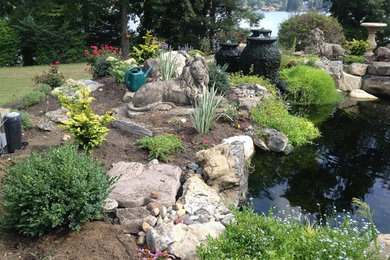 Design ideas for a mid-sized full sun side yard mulch water fountain landscape in New York.
