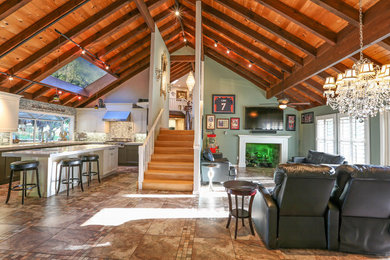Large trendy open concept ceramic tile and brown floor living room photo in San Francisco with gray walls, a standard fireplace, a plaster fireplace and a wall-mounted tv