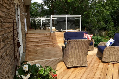Example of a large backyard deck design in Other