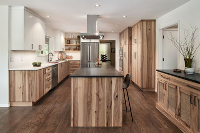 Example of a mid-sized trendy u-shaped dark wood floor open concept kitchen design in Portland with an undermount sink, flat-panel cabinets, medium tone wood cabinets, quartz countertops, white backsplash, quartz backsplash, stainless steel appliances, an island and multicolored countertops