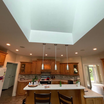 3 Finishes on Kitchen Cabinetry with Galley Workstation in Island and Wine Bar