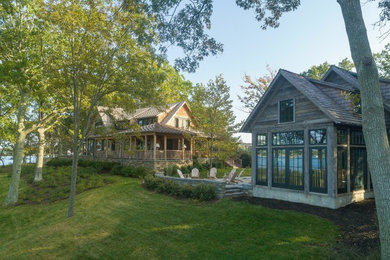 Example of a large mountain style brown two-story wood exterior home design in New York with a shingle roof