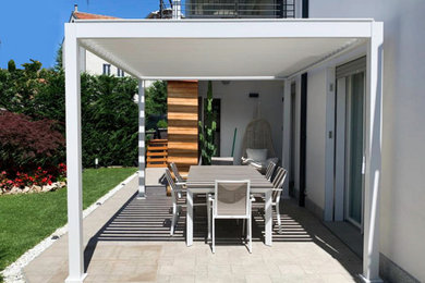 Ispirazione per un giardino moderno esposto in pieno sole davanti casa con gazebo e recinzione in pietra