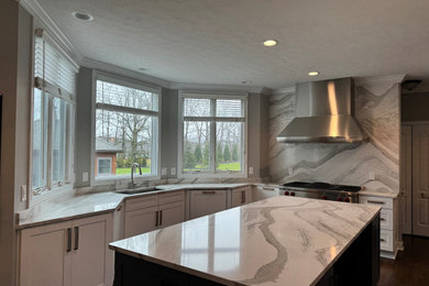 Large minimalist vinyl floor and brown floor eat-in kitchen photo in Cleveland with an undermount sink, shaker cabinets, white cabinets, quartz countertops, multicolored backsplash, quartz backsplash, stainless steel appliances, an island and multicolored countertops