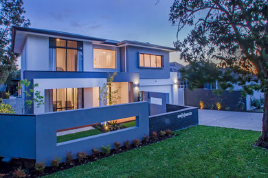 Photo of a large contemporary two-storey stucco grey house exterior in Perth with a hip roof and a metal roof.