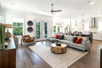 Example of a large trendy open concept brown floor living room design in Miami with white walls and a wall-mounted tv