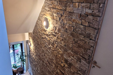 Exemple d'un escalier tendance en L de taille moyenne avec des marches en bois, un garde-corps en métal et un mur en parement de brique.
