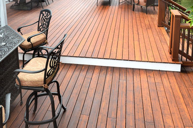 This is an example of a large transitional backyard deck in Other with an awning.