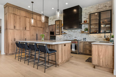 Inspiration for a southwestern u-shaped light wood floor and beige floor kitchen remodel in Salt Lake City with an undermount sink, shaker cabinets, medium tone wood cabinets, gray backsplash, stainless steel appliances, an island and gray countertops