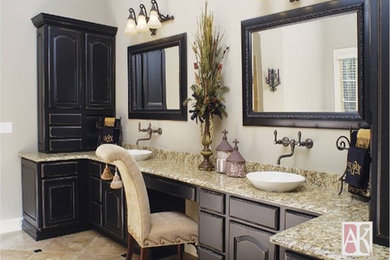 This is an example of a large traditional master bathroom in Atlanta with a vessel sink, raised-panel cabinets, black cabinets, granite benchtops, beige tile, stone tile, grey walls and travertine floors.
