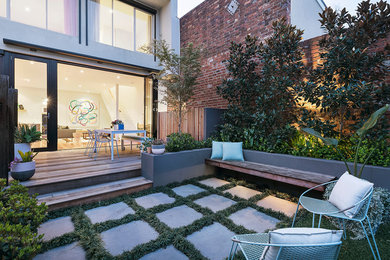 This is an example of a contemporary backyard garden in Other with concrete pavers.