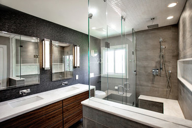 Inspiration for a large modern master bathroom in Toronto with flat-panel cabinets, dark wood cabinets, a drop-in tub, an open shower, a one-piece toilet, white tile, grey walls, ceramic floors, a drop-in sink and solid surface benchtops.