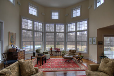 Living room - large open concept medium tone wood floor living room idea in New York with beige walls