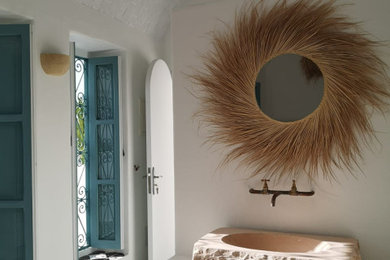 パリにある低価格の中くらいな地中海スタイルのおしゃれなバスルーム (浴槽なし) (オープン型シャワー、白いタイル、白い壁、セメントタイルの床、オーバーカウンターシンク、グレーの床、オープンシャワー、洗面台1つ) の写真
