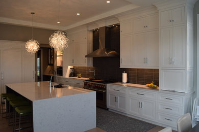 Photo of a large transitional l-shaped eat-in kitchen in Chicago with beaded inset cabinets, white cabinets, quartz benchtops, black splashback, ceramic splashback, stainless steel appliances, light hardwood floors, with island and multi-coloured floor.