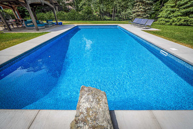 Pool landscaping - large traditional backyard concrete and rectangular natural pool landscaping idea in Ottawa