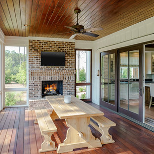 Foto de galería de estilo de casa de campo, de tamaño medio, con suelo de madera oscura, chimenea tradicional, marco de chimenea de ladrillo, techo estándar y suelo marrón