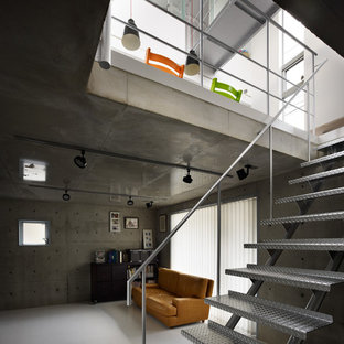 Aménagement d'une salle de cinéma industrielle de taille moyenne et fermée avec un mur gris, un sol en linoléum, un téléviseur fixé au mur et un sol blanc.