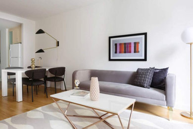 Diseño de salón con barra de bar abierto contemporáneo de tamaño medio con paredes blancas, suelo de madera clara y televisor colgado en la pared