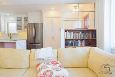 Modelo de biblioteca en casa abierta minimalista de tamaño medio con paredes blancas, suelo de madera clara y televisor colgado en la pared