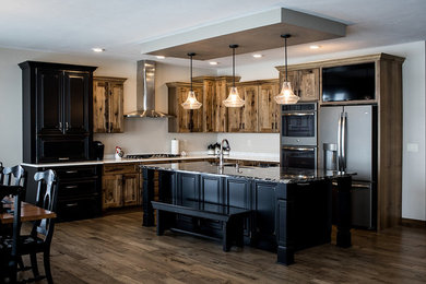 Inspiration for a mid-sized transitional l-shaped medium tone wood floor and brown floor open concept kitchen remodel in Other with a farmhouse sink, shaker cabinets, medium tone wood cabinets, granite countertops, stainless steel appliances and an island