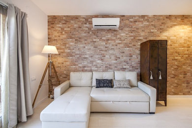 Modelo de sala de estar tipo loft contemporánea de tamaño medio con paredes blancas, suelo de madera clara y televisor colgado en la pared