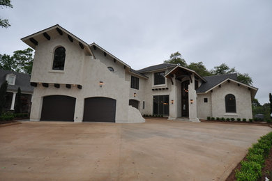 Large contemporary beige two-story stucco gable roof idea in New Orleans