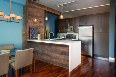 Open concept kitchen - small contemporary galley medium tone wood floor open concept kitchen idea in Chicago with a double-bowl sink, flat-panel cabinets, brown cabinets, quartz countertops, blue backsplash, glass tile backsplash, stainless steel appliances and a peninsula