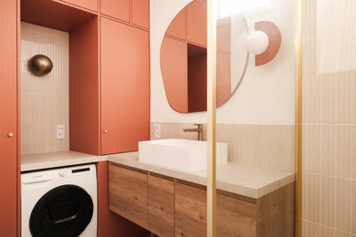 Idée de décoration pour une petite buanderie tradition en L multi-usage avec un évier posé, un placard à porte plane, des portes de placard beiges, plan de travail carrelé, une crédence en mosaïque, un mur beige, un sol en carrelage de céramique, un lave-linge séchant, un sol beige et un plan de travail beige.