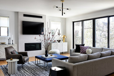 Transitional medium tone wood floor and brown floor living room photo in DC Metro with white walls, a ribbon fireplace and a wall-mounted tv