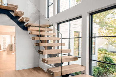 Inspiration för stora moderna l-trappor i trä, med öppna sättsteg och räcke i glas