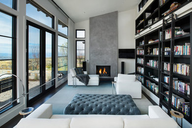 Inspiration for a mid-sized contemporary open concept family room in Denver with a library, white walls, a standard fireplace, a concrete fireplace surround, a wall-mounted tv, dark hardwood floors and brown floor.