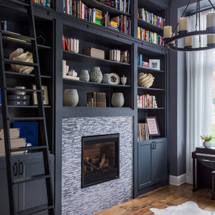 Inspiration för ett mellanstort vintage arbetsrum, med ett bibliotek, svarta väggar, mellanmörkt trägolv, en standard öppen spis, en spiselkrans i trä och brunt golv