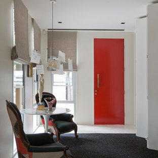 Inredning av en eklektisk hall, med vita väggar, heltäckningsmatta, en enkeldörr, en röd dörr och svart golv