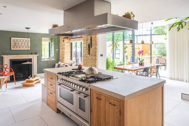Large classic l-shaped open plan kitchen in Gloucestershire with shaker cabinets, an island, medium wood cabinets and stainless steel appliances.