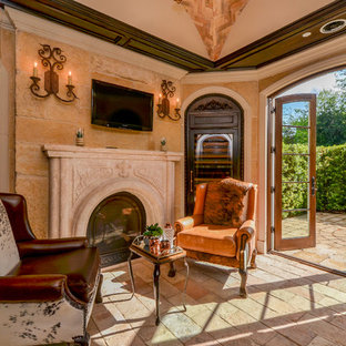 This is an example of a small mediterranean formal enclosed living room in Houston with beige walls, a standard fireplace, a concrete fireplace surround and a wall mounted tv.