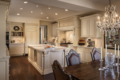 Inspiration for a large timeless dark wood floor eat-in kitchen remodel in Phoenix with raised-panel cabinets, beige cabinets, granite countertops, stone tile backsplash, paneled appliances, an island and a farmhouse sink