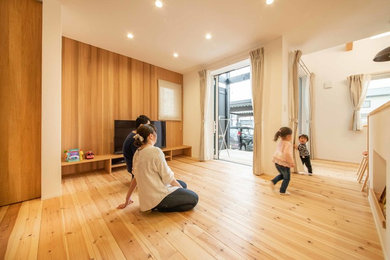 他の地域にあるおしゃれなリビング (白い壁、淡色無垢フローリング、据え置き型テレビ) の写真
