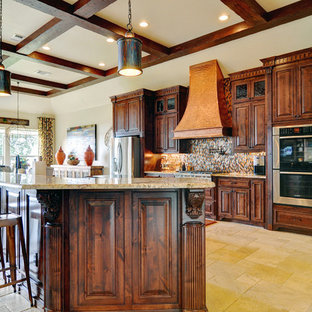 Große Klassische Küche in U-Form mit Travertin, Vorratsschrank, Unterbauwaschbecken, profilierten Schrankfronten, hellbraunen Holzschränken, Granit-Arbeitsplatte, Küchenrückwand in Metallic, Glasrückwand, Küchengeräten aus Edelstahl und Kücheninsel in Dallas